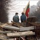 Photo of two men with a Lithuanian flag guarding a barricade