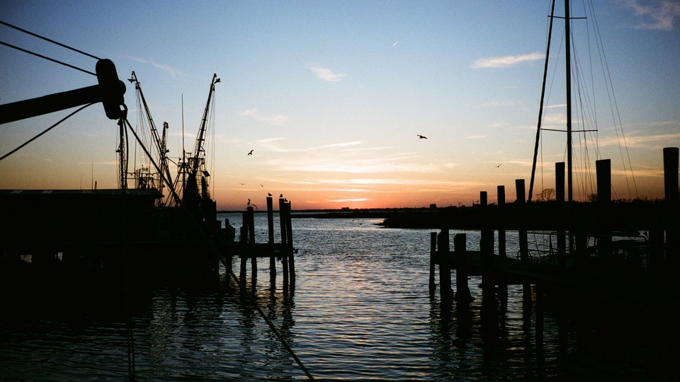 Sun sets over water at a fishing dock