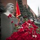 A woman holding a portrait of Stalin places flowers near the monument signifying Joseph Stalin's grave near the Kremlin wall to mark the anniversary of Stalin's birth.