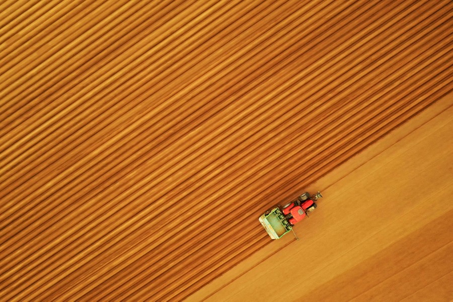 An aerial view of a tractor working in a field