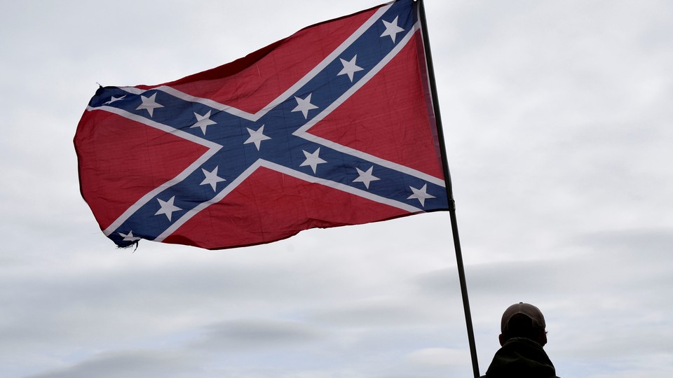 A Confederate flag waves in the wind.