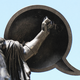 A statue with a quote bubble for a shield