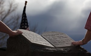 Two people touch the Ten Commandments Monument