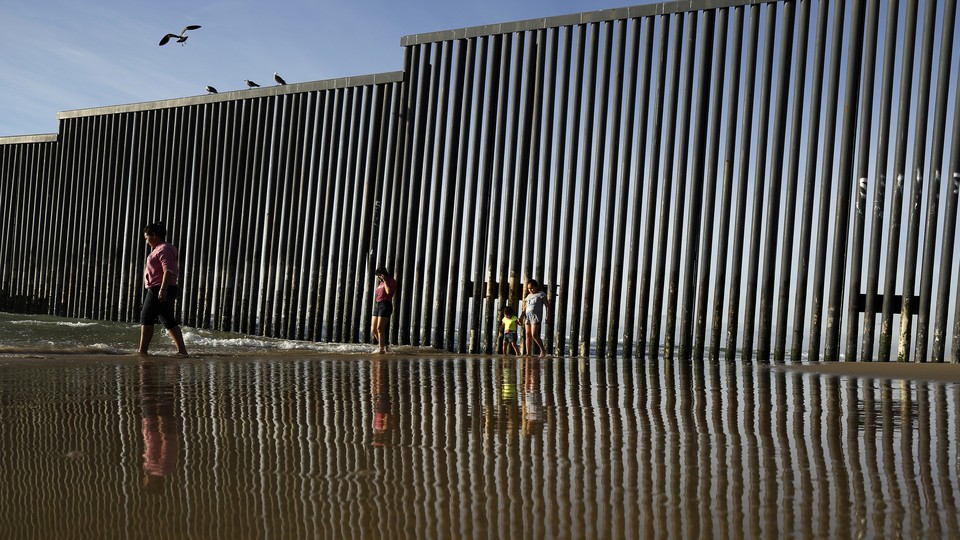The border wall separating Tijuana and San Diego is reflected in the Pacific Ocean