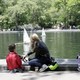 A mother and child look at miniature sailboats. 