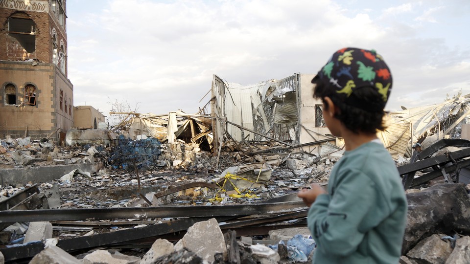 A child looks at a building destroyed by U.S. air strikes in Yemen
