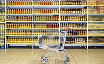 An image of a beverage aisle with a cart in front of it.