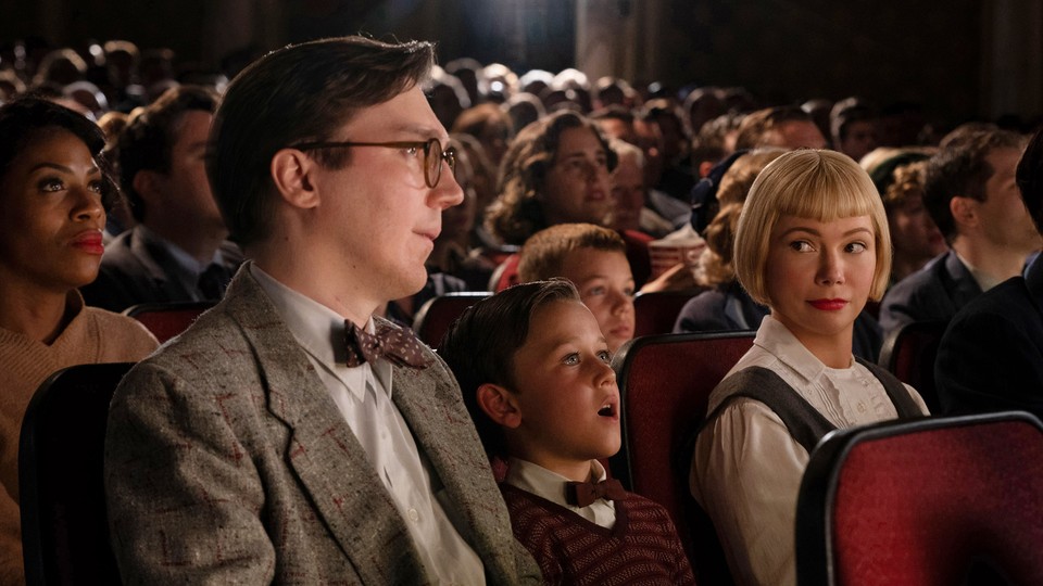 Paul Dano, Mateo Zoryon Francis-DeFord, and Michelle Williams sit in a movie theater in "The Fabelmans"