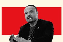 Black and white photo of Dan Bongino speaking placed in front of a red background