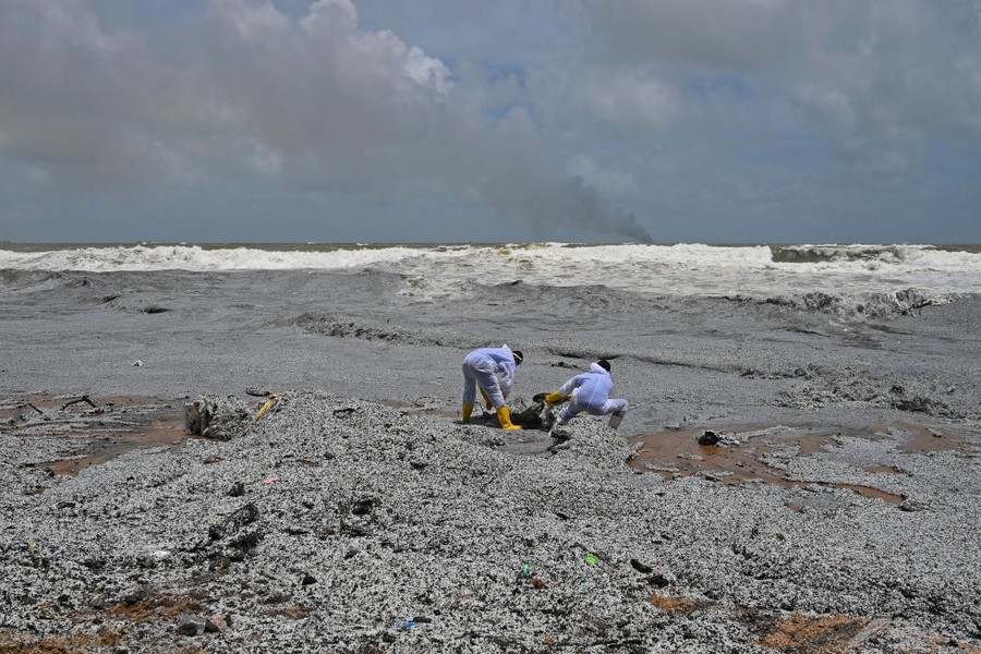 Navy members work to remove debris from a beach.