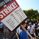 A writer's strike picket sign listing demands vs. streamer revenue