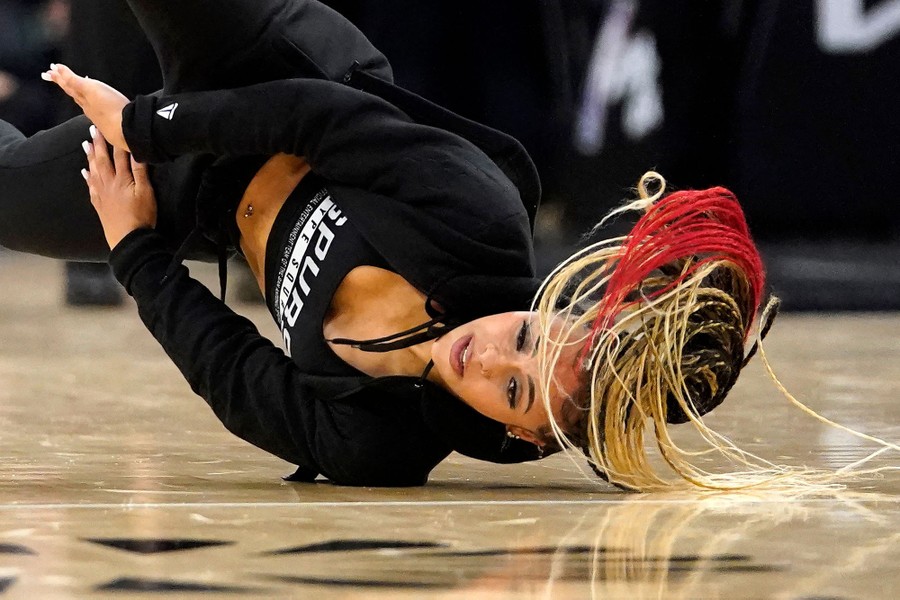 A dancer spins on the floor during a halftime show.