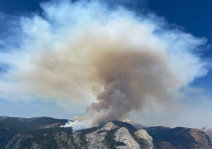 Tall plumes of smoke rise from a wildfire in Yosemite National Park.
