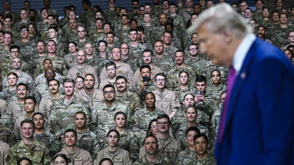 Trump in the foreground with U.S. troops behind him in May 2025 at a US air base southwest of Doha