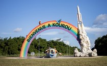 A display in the town of Kourou, French Guiana, featuring a rainbow arch and a rocket