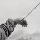 Raul Rodriguez's hand rested on barbed wire in black and white.