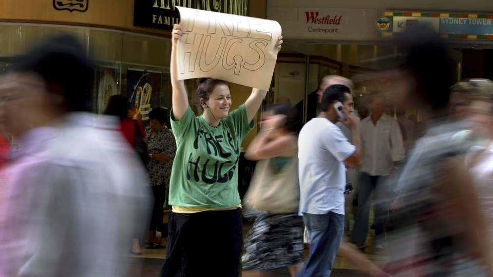 Woman holding "Free Hugs" sign