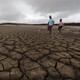 A family negotiates their way through caked mud around a dried up section of the Theewaterskloof dam.