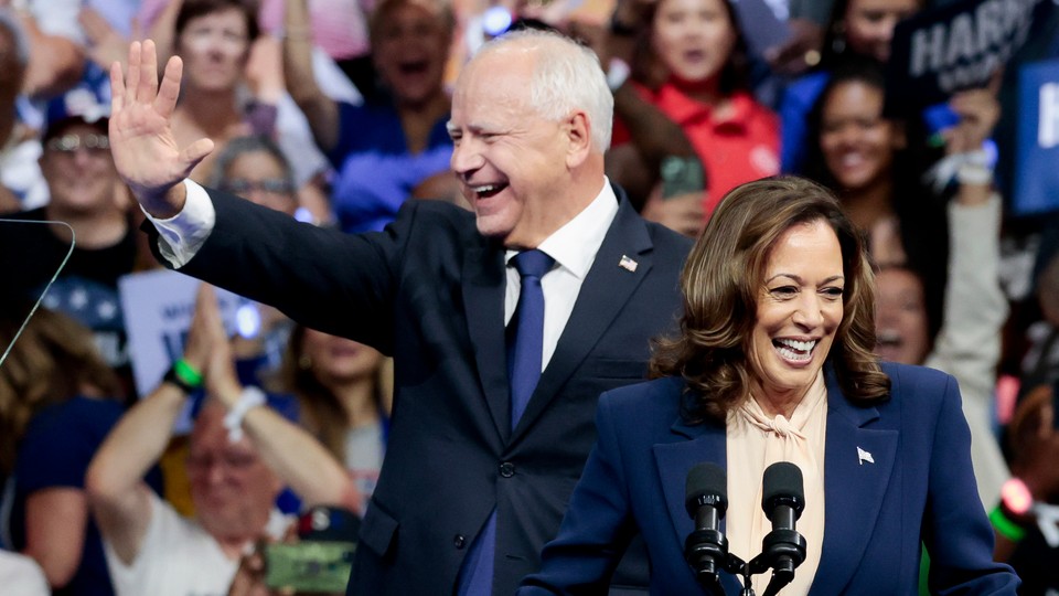 Minnesota Governor Tim Walz smiles and waves next to Kamala Harris