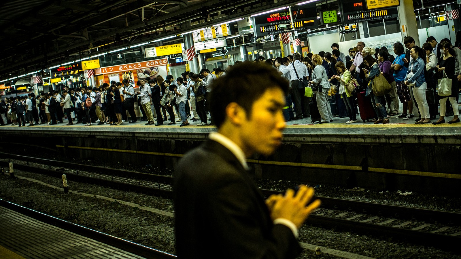 Two young men kissing, in the middle of tokio, night