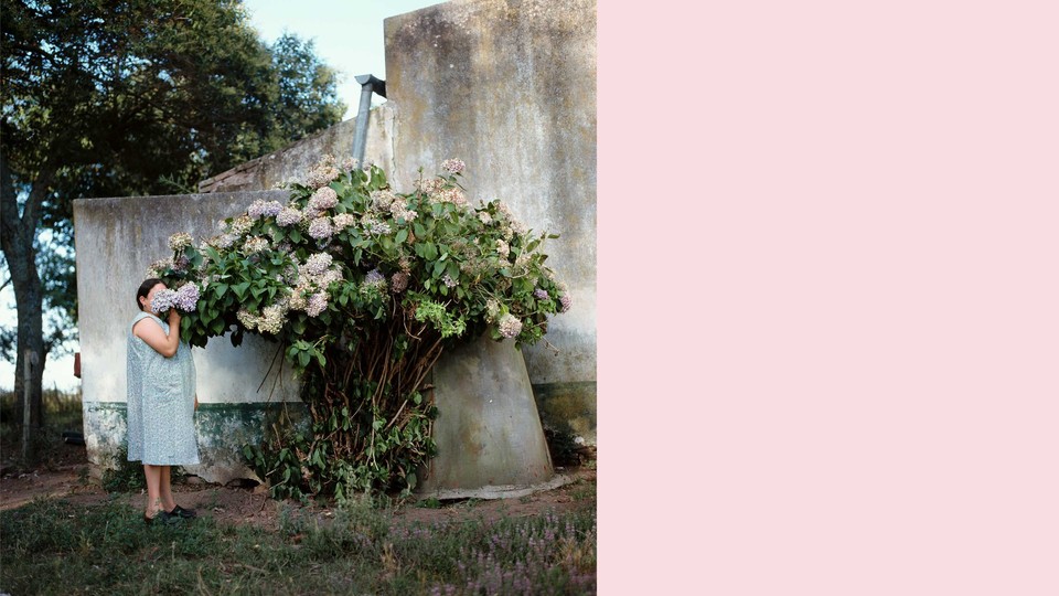 An image of a woman smelling a large bouquet of flowers