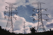 An image of transmission lines sitting atop two large metal structures