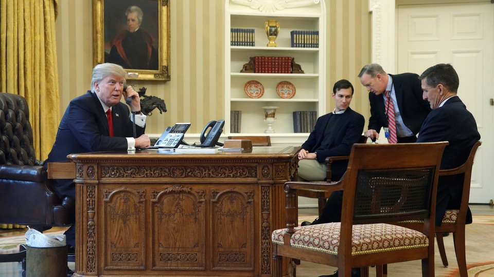 President Trump, accompanied by senior aides, makes a phone call in the Oval Office.