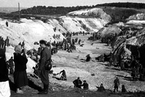 A black-and-white photo of Soviet prisoners of war covering a mass grave at Babi Yar