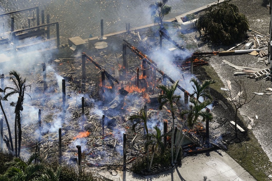 An aerial view of the still-burning ruins of a destroyed house.