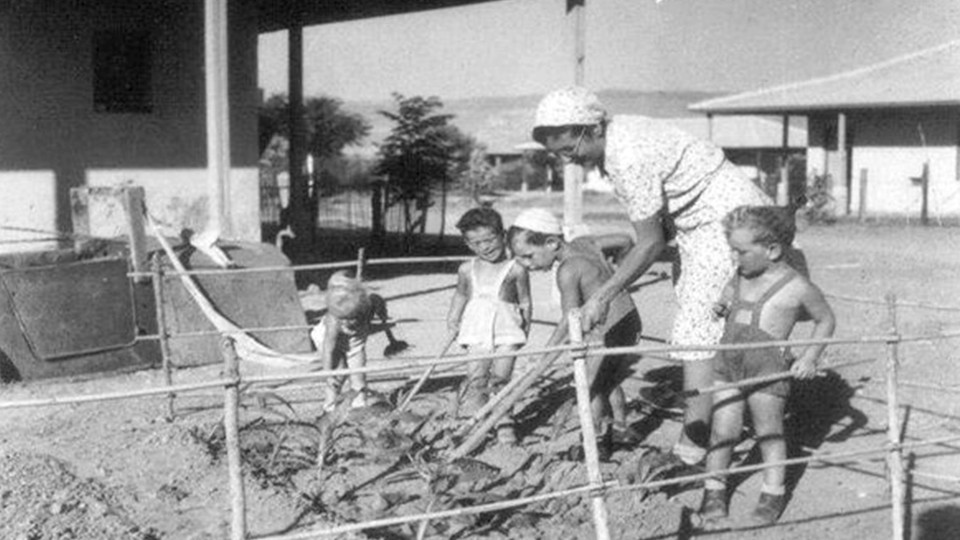 A woman and children tending a garden