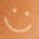 Tanned skin with pale smiley face drawn on it