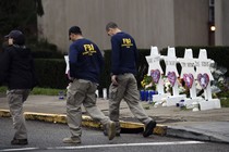 FBI officers walk past a memorial outside the Tree of Life synagogue in Pittsburgh.