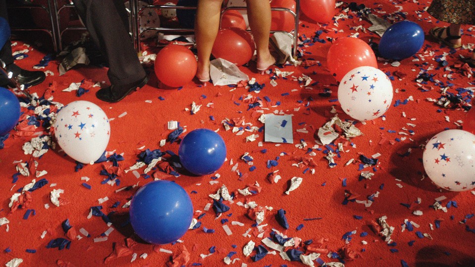 An image of a red carpeted floor covered in red, white, and blue confetti and balloons.