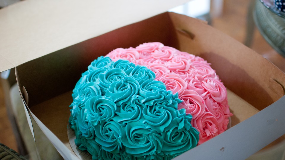 A cake frosted in two colors: one half blue, the other half pink