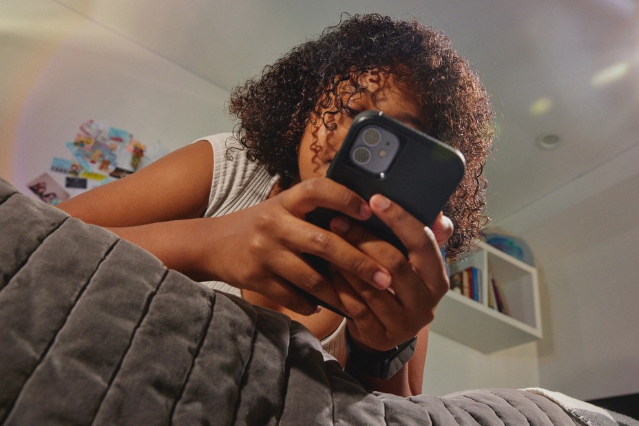 teen on her phone in her room
