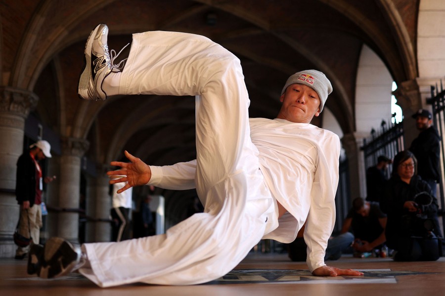 A dancer spins on his hands on the floor, whipping his legs around.