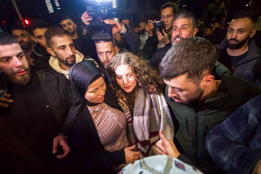 A crowd gathers around a young woman