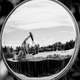 An oil pumpjack is reflected in a mirror as it operates on August 5, 2022, near Ventura, California.