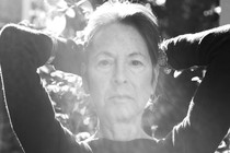 A black-and-white photo of Louise Glück in sunlight