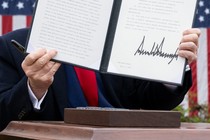 Donald Trump holding a document with his signature