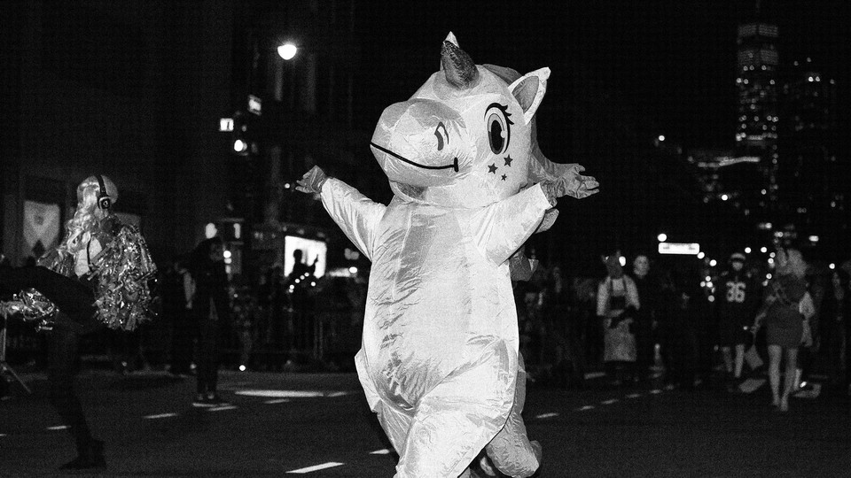 A person dressed as a unicorn parading down the street in New York city