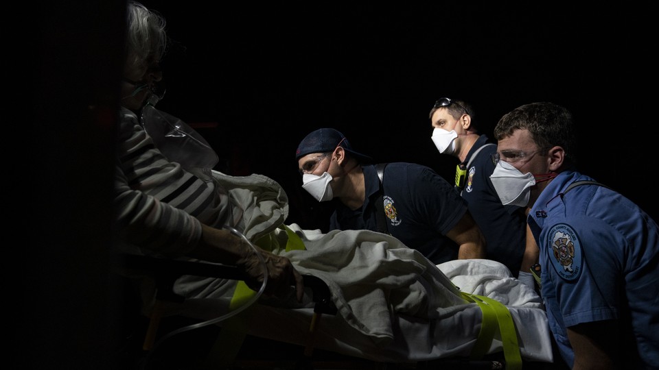 Paramedics prepare to transport a coronavirus patient to the hospital.