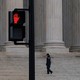Color photograph of a red "stop" hand sign on a street light outside the Supreme Court building.