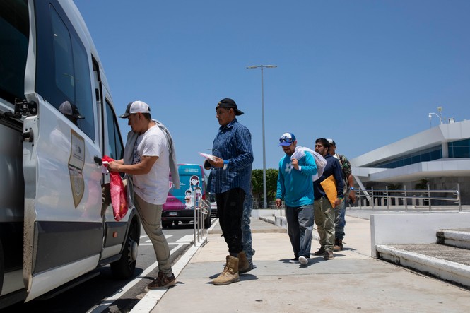Men lining up to board onto a bus in Tapachula, Mexico