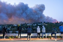 A photo of people in L.A. watching the wildfire rampaging across a hillside