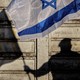 A photo of a silhouette of a man holding an Israeli flag