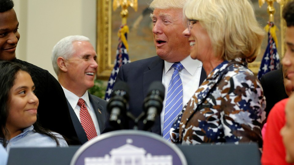 Vice President Mike Pence, President Donald Trump, and Education Secretary Betsy DeVos are seen laughing at a school-choice event in Washington, D.C.