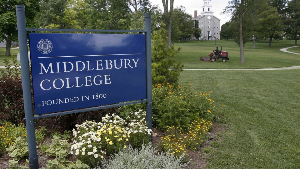 A sign reads "Middlebury College, founded in 1800." A lush green lawn with a tractor fills the rest of the photo.