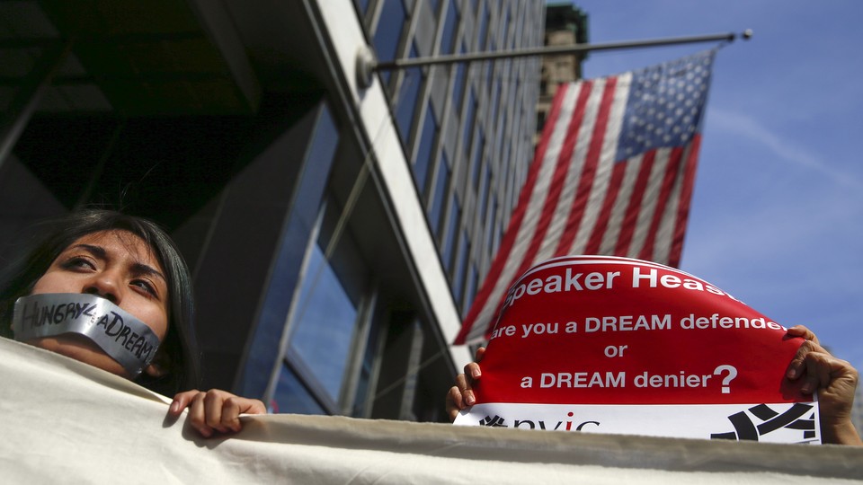 A young woman with tape on her mouth that reads "Hungry4aDream" stands in front of an American flag.