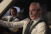 Nathan Fielder wears a white wig and fake mustache, posing as an airline pilot
